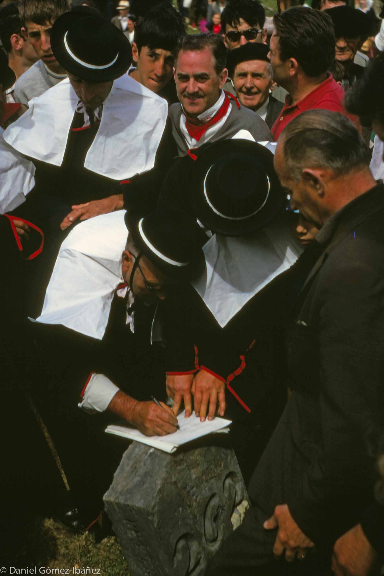 Signing the Roncal-Barétous treaty on the boundary stone. At the end of the ceremony the representatives of the two valleys, dressed in their seventeenth-century robes of office, place their hands atop one another on the boundary stone and with the words "patz abant" swear eternal peace. Even the German occupation of France during World War II did not stop the annual ceremony. [Col de la Pierre St. Martin, Spain and France, 1968]