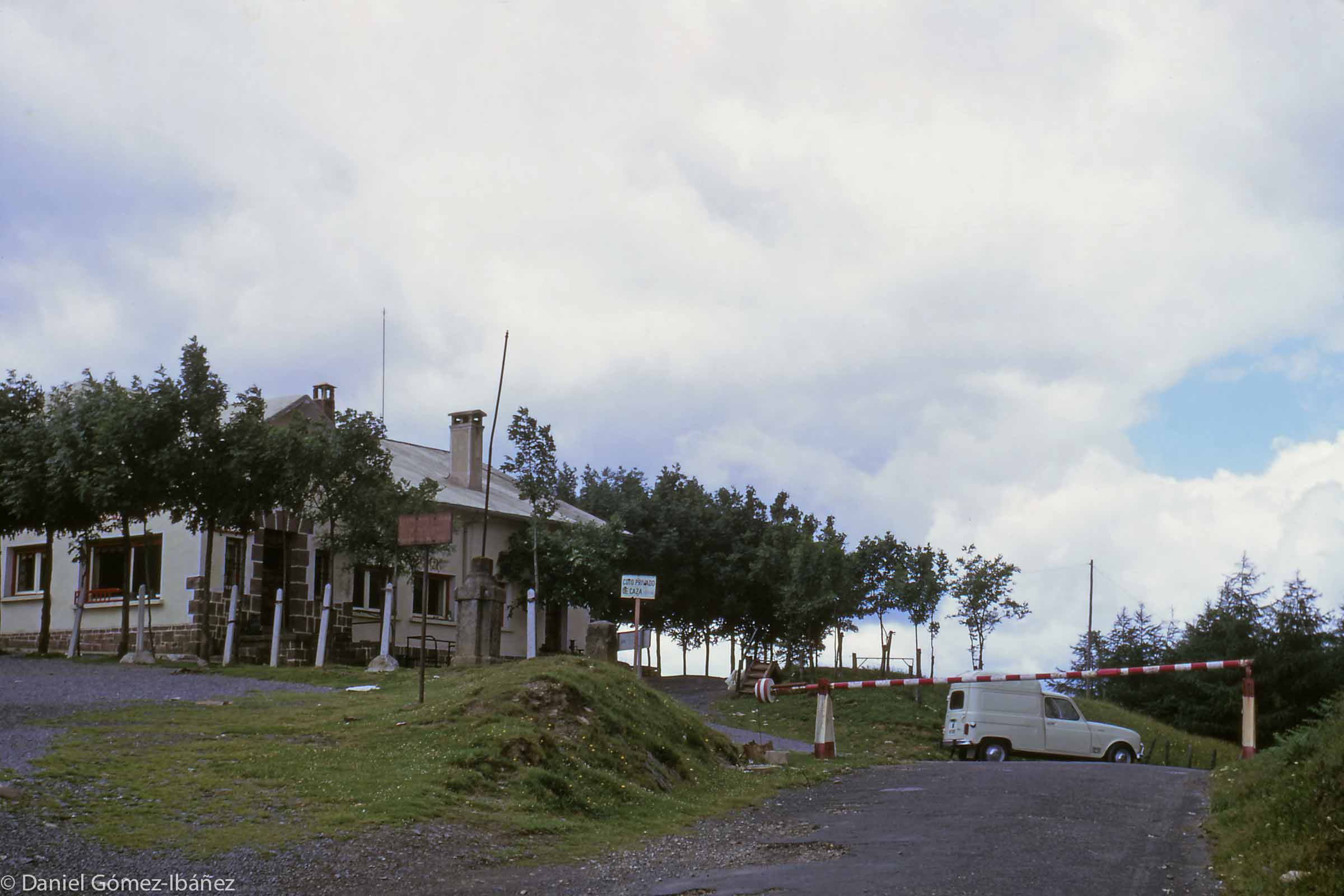 Smuggling has long been a source of income for Basques living near the frontier between France and Spain. The building at this crossing point is not the customs' house but a Spanish store selling wine and other items to French households. The parking lot (in France) can be seen at the left foreground. The line of posts marks the boundary. [Col d'Ispéguy on the road between St. Etienne de Baïgorry in France and Erratzu in Spain, 1973]