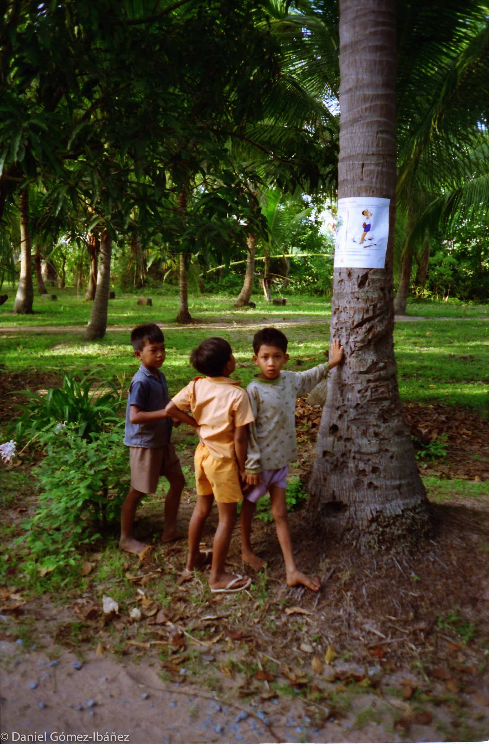 Danger! Don't Touch! -- in Takeo province, Cambodia, children look at a poster with cartoons showing the dangers of buried landmines. Mines remain hidden and lethal for decades. They stay behind to kill and maim long after the conflict ends and the soldiers have gone. Civilians are the most frequent casualties. ©1996